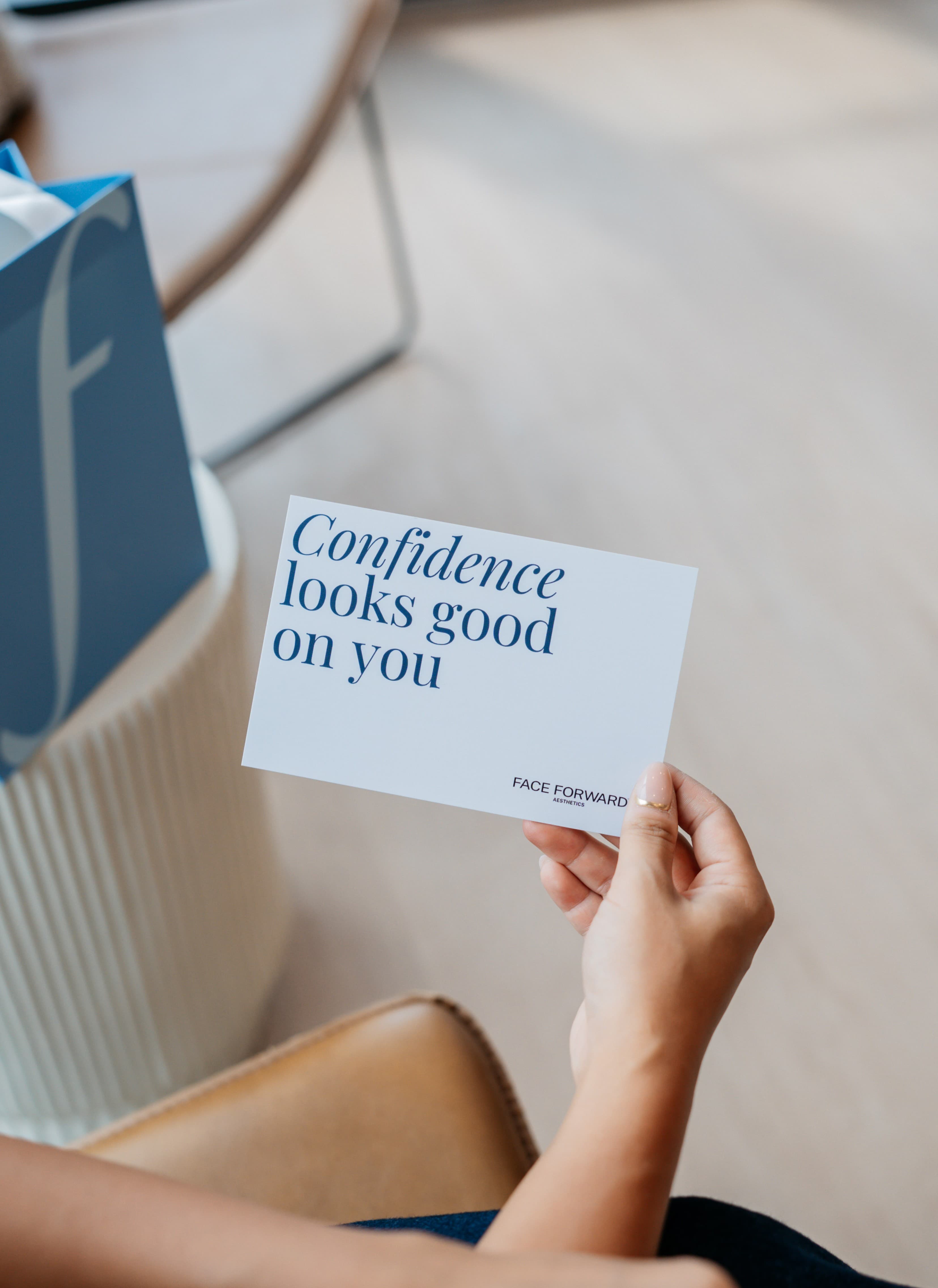 Hand holding a card that reads “Confidence looks good on you”